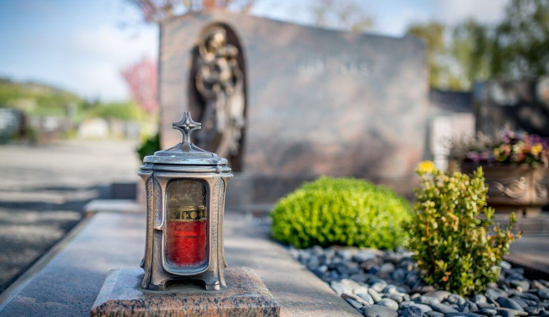 Kerzen oder Laternen werden an einem Grab niedergelegt, um sein Mitgefühl auszudrücken und die Wertschätzung gegenüber dem Verstorbenen auszudrücken. | Bildquelle: © mh90photo - Fotolia