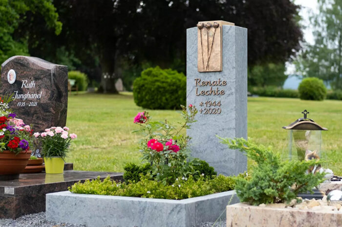 Grabstein mit Bronzelement für ein Urnengrab aus Granit mit Einfassung - Moderne Grabbepflanzung im Sommer mit Blumen