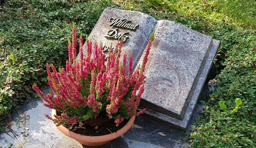 Liegestein für ein Urnengrab in Buchform mit Grabschale und Bepflanzung