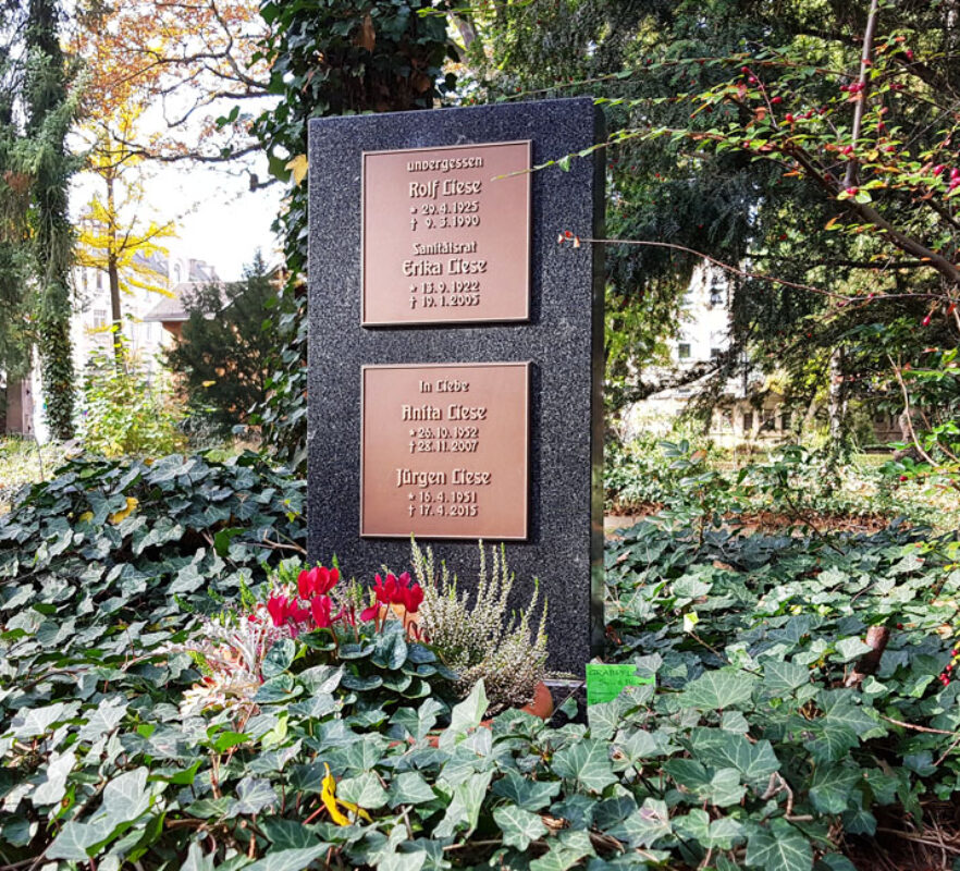 Urnengrabstein aus Granit mit Bronzeplatten für ein Familiengrab