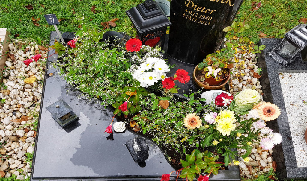 Grabbepflanzung Urnengrab mit Blumen und Bodendeckern im Sommer Grababdeckung mit Platten Friedhof Saalfeld