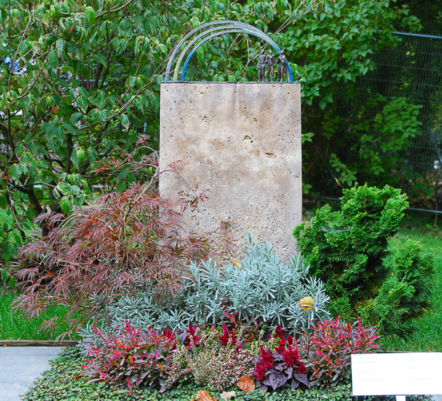 Mustergrab/Mustergrabstein Urnengrab mit Bepflanzung / Grabstein mit Regenbogen Symbol