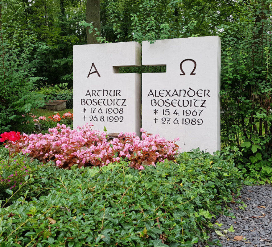 Doppelgrab /Doppelgrabstein mit immergrüner Bepflanzung / zweiteiliger Grabstein mit Kreuz