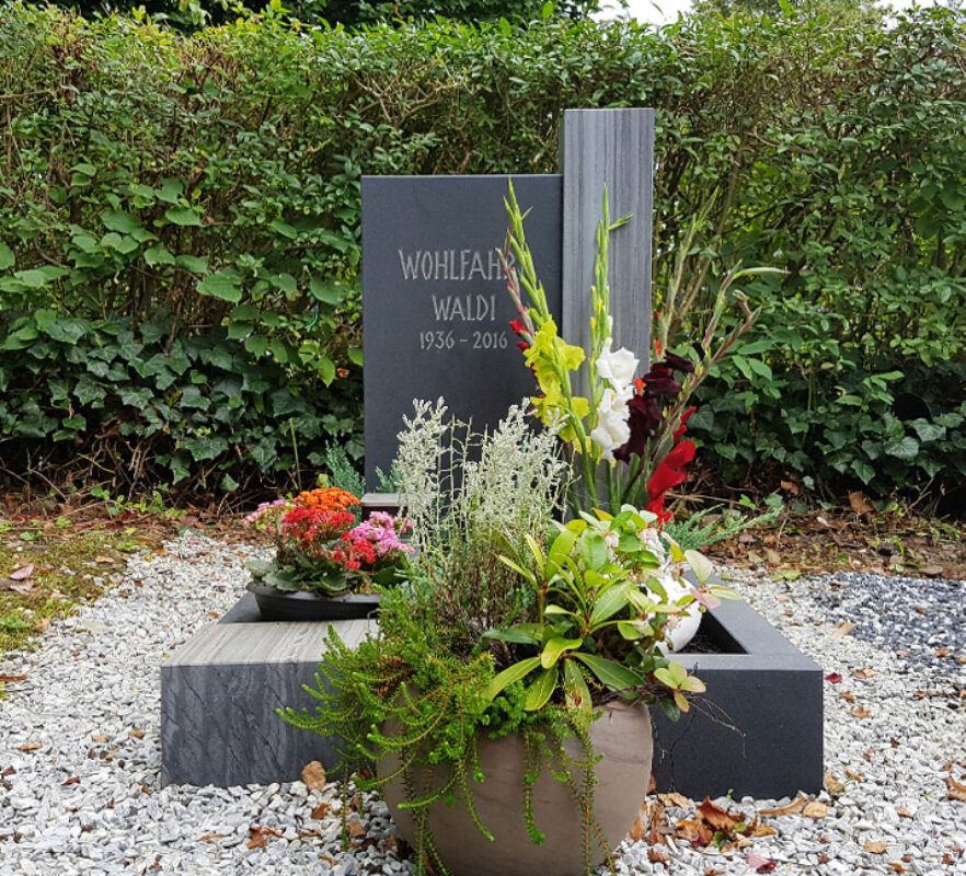 Zweiteiliger Grabstein aus Granit mit Grabeinfassung / Grabstein für ein Urnengrab