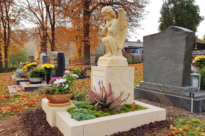 Urnengrab mit Einfassung und Grabengel aus hellem Sandstein