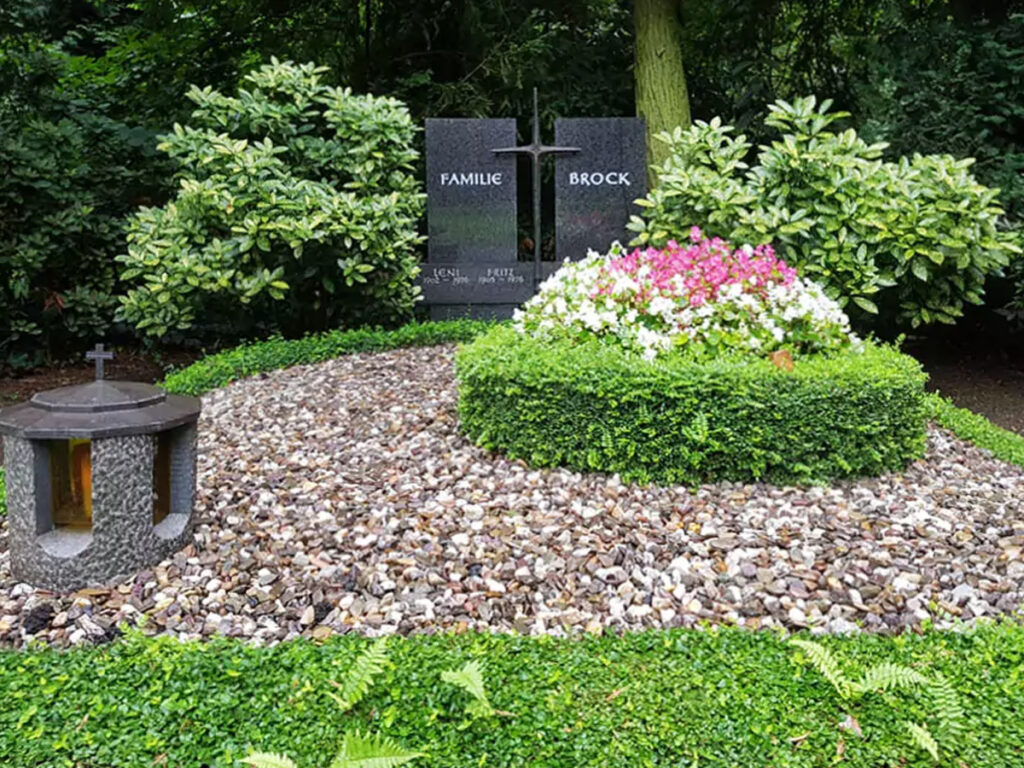 Schöne Familiengrabanlage mit schlichtem Grabstein aus Granit - Grabgestaltung mit Kies & immergrünen Bodendeckern auf dem Südfriedhof Köln.