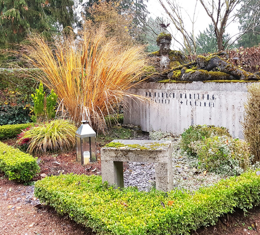 moderne Grabanlage aus Kalkstein - lebensgroße Steinskulptur