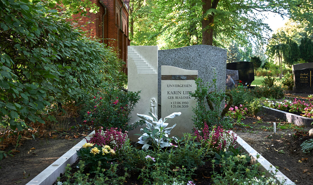 zweiteiliger Doppelgrabstein aus Kalkstein mit Bronzeelement / Friedhof