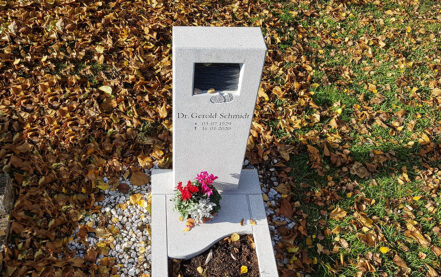 Impressionen vom Friedhof: Modernes Urnengrabmal aus sandgestrahltem hellen Granit mit Öffnung