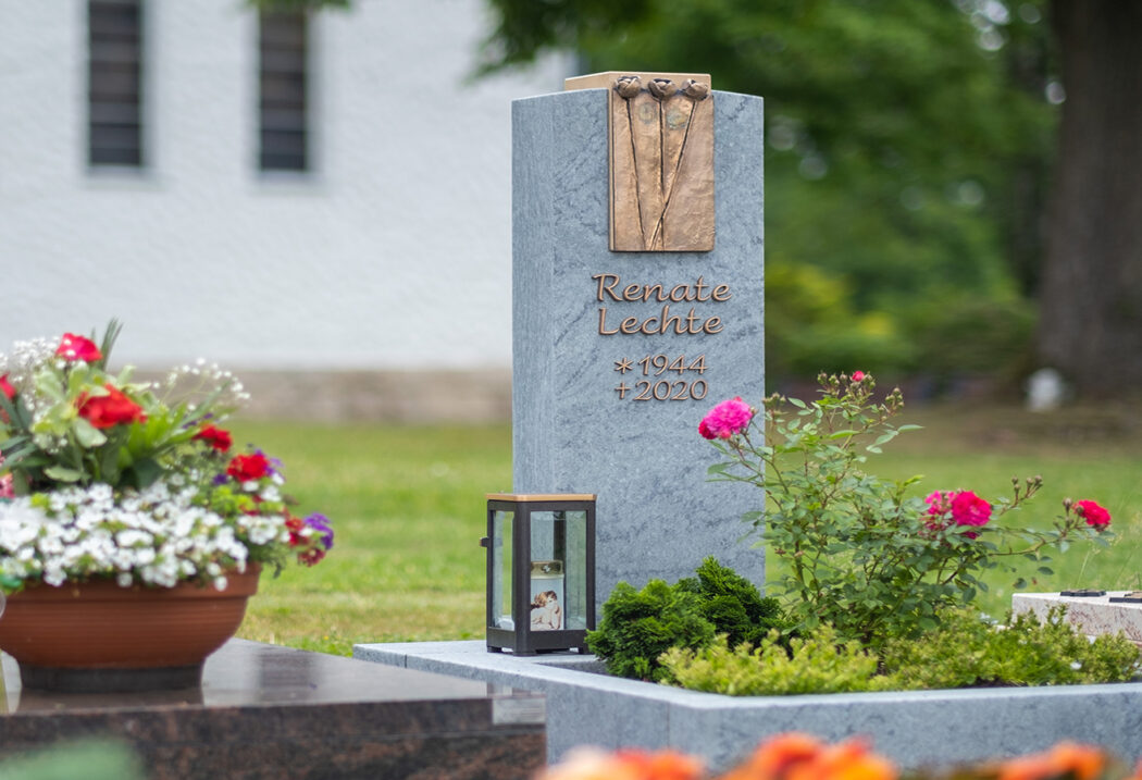 Moderner Grabstein für ein Urnengrab mit Einfassung und Grabgestaltung mit Bodendeckern