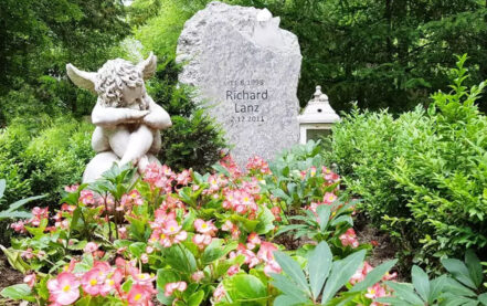Gestaltungsidee für ein Kindergrab mit einfachen Grabstein und schöner Grabdekoration mit Engel.