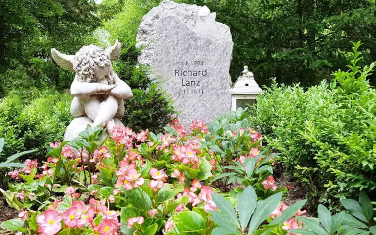 Gestaltungsidee für ein Kindergrab mit einfachen Grabstein und schöner Grabdekoration mit Engel.
