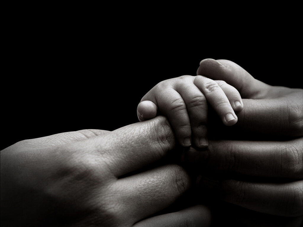 Eltern mit der kleinen Hand eines Babys