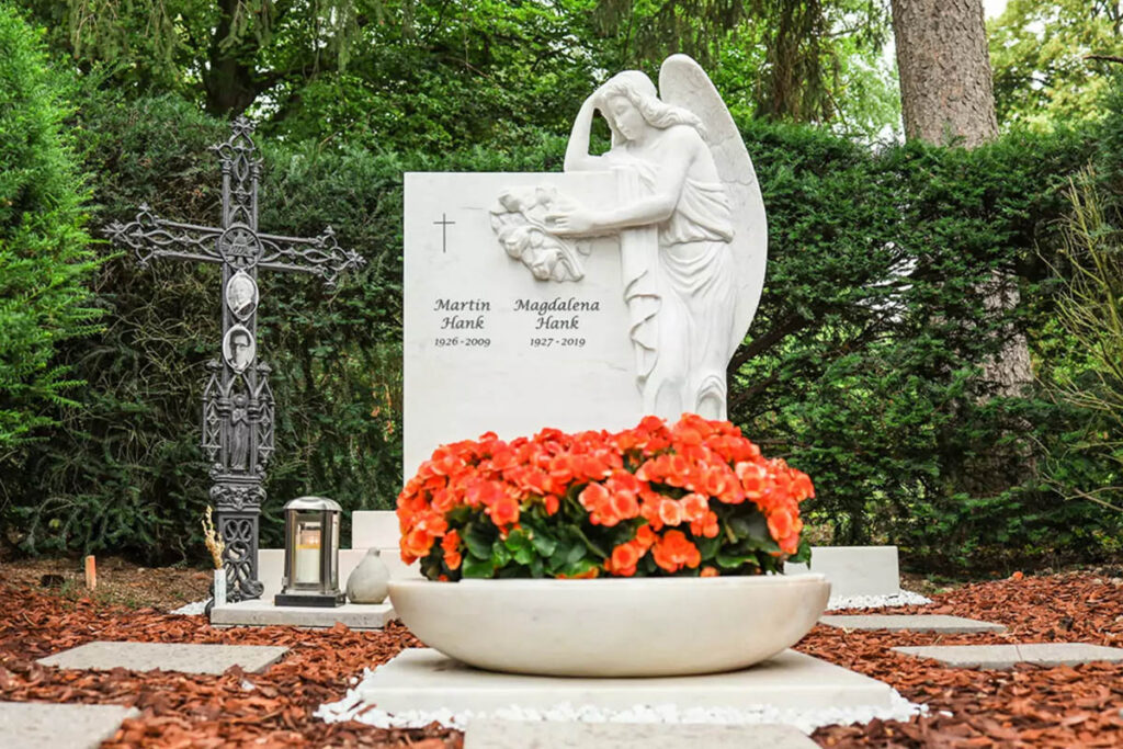 Doppelgrabstein mit Grabengel aus Marmor für ein Familiengrab - Grabgestaltung mit Pflanzschale und Rindenmulch