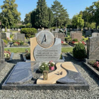 Diese moderne Grabanlage ist ein Doppelgrab für Karl und Elisabeth Müller  gestaltet aus grauem Granit mit Wellenstruktur und hellem Sandstein. Der aufrechte Grabstein trägt eine kreisrunde Sonnenuhr und Gedenkinschriften. Die passenden Bodenplatten sind mit einer Laterne  Blumen und einer Schmetterlingsfigur verziert und liegen auf grauem Kies. 